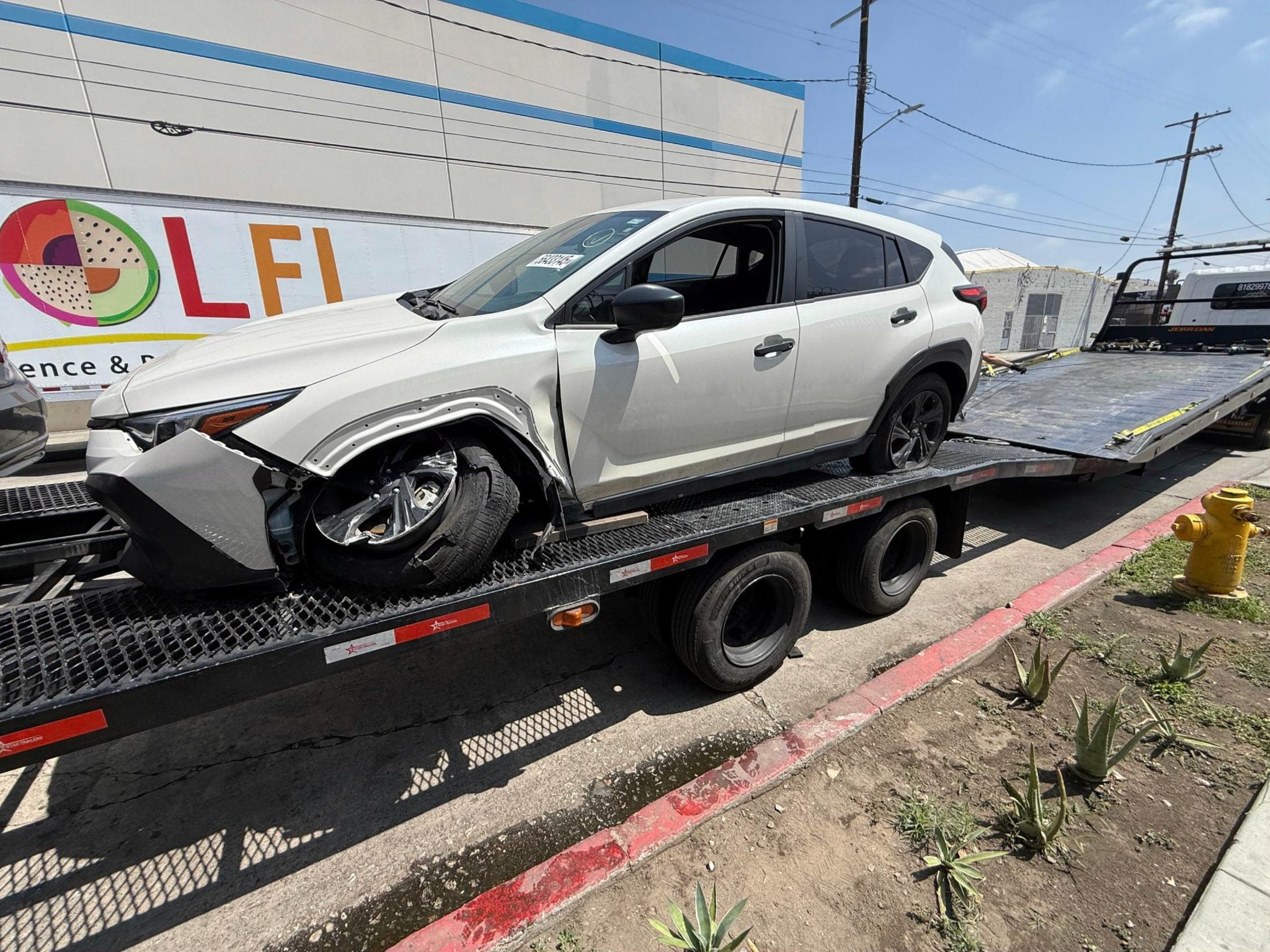 Damaged white SUV on our flatbed